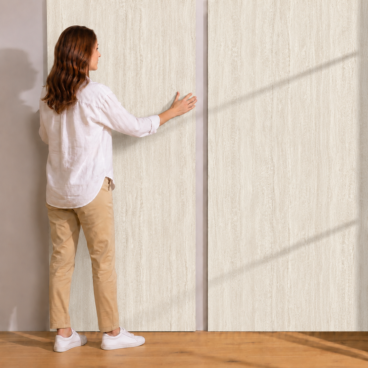 Mulher a tocar em folhas de travertino branco na parede